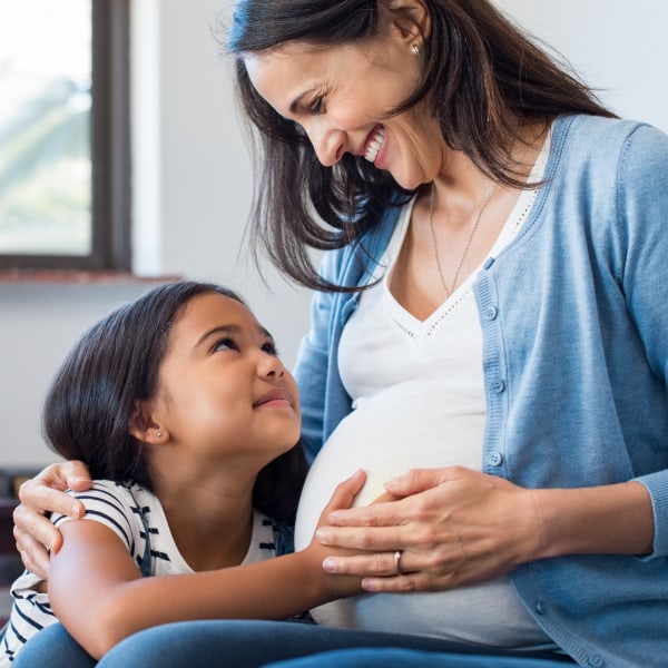 A pregnant mother with her young daughter