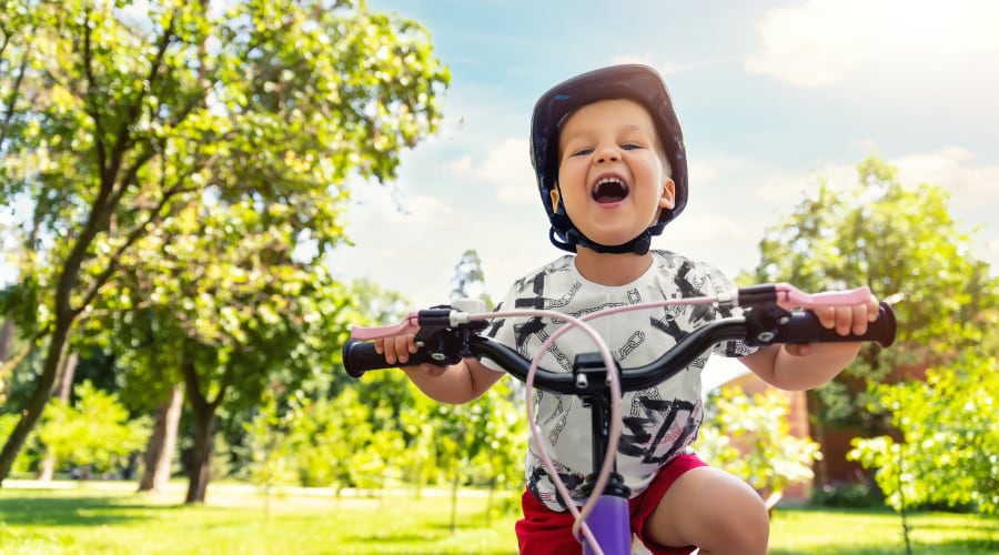A young boy rides his bike in the park