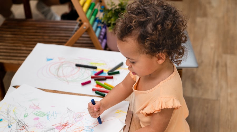 A young girl coloring with crayons