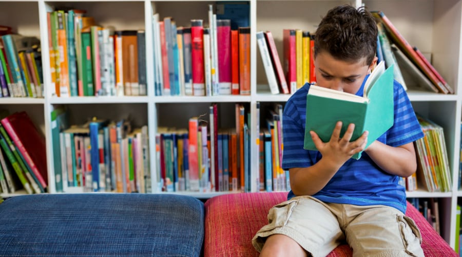 A young boy reads in the school library