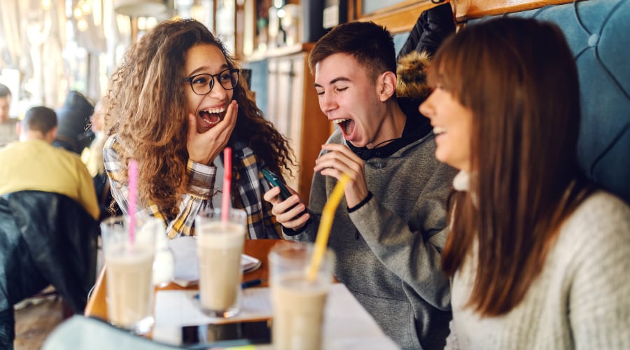 A group of energetic teens gathers at a coffee shop