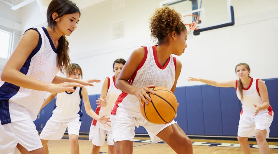 Adventure Pediatrics Teen girls playing high-school basketball