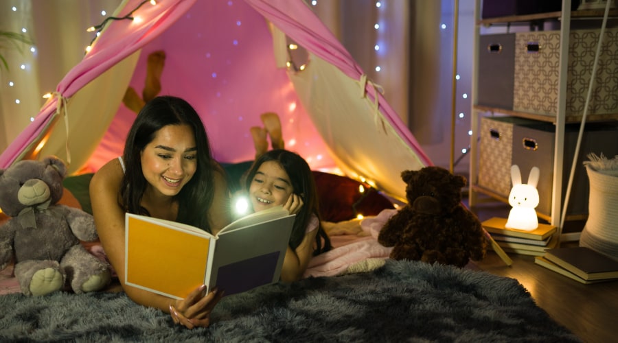 Adventure Pediatrics Siblings in a cozy indoor fort, reading a story book
