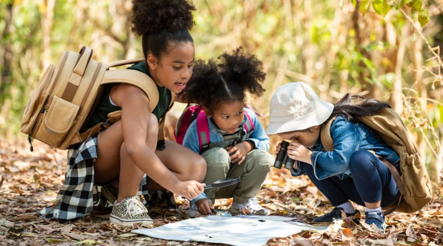 Adventure Pediatrics A group of kids on an outdoor adventure study a map